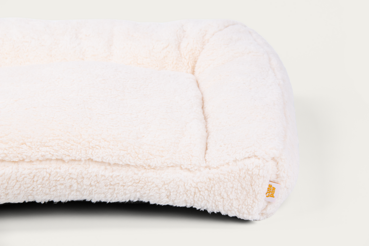 Close-up of the Cloud Open Bolster bed's right bolster and Cute Paw label